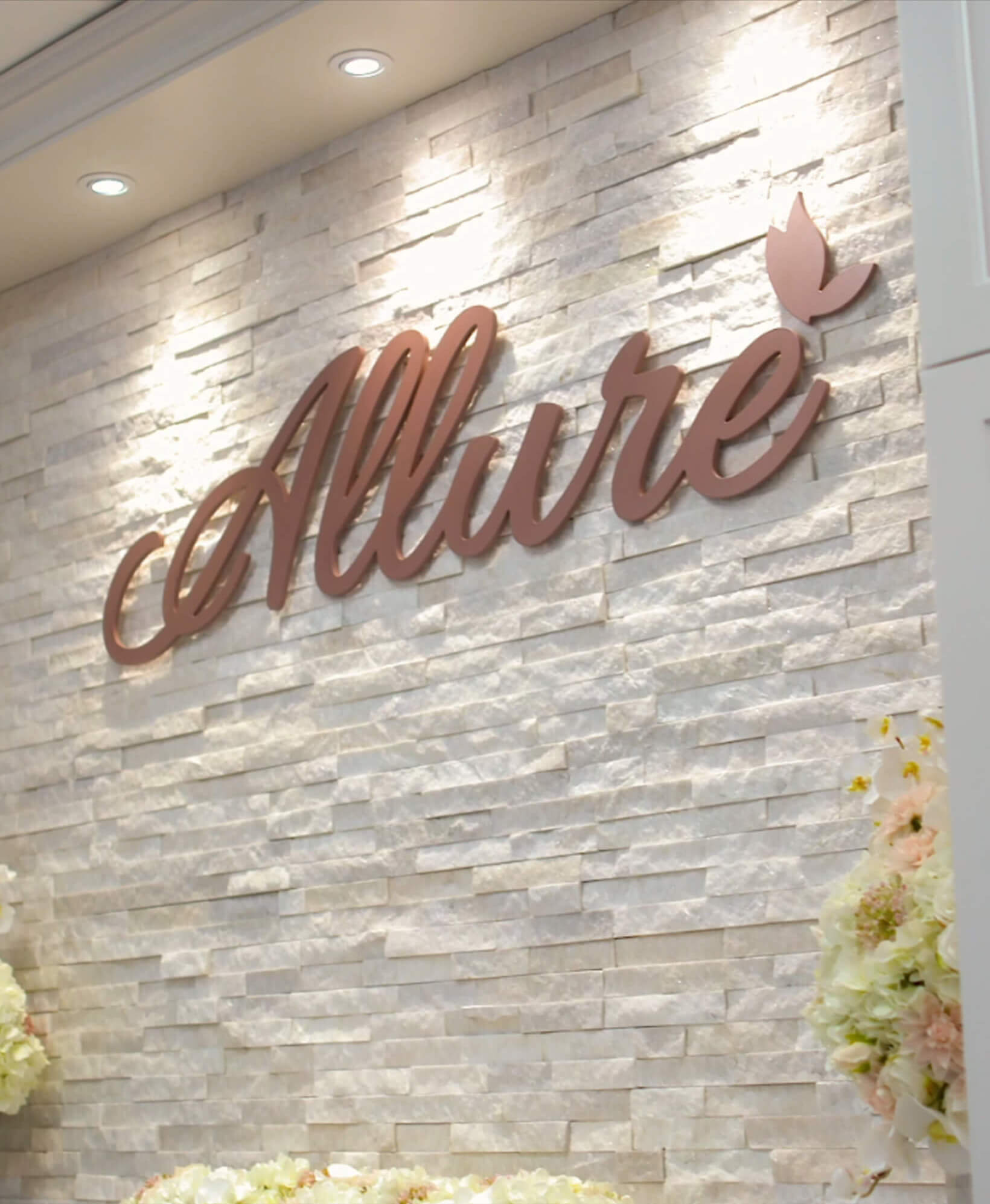 Allure sign on white rock building.