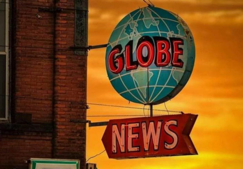 A neon sign of a globe with a red arrow beneath it. The sign reads, "Globe news".