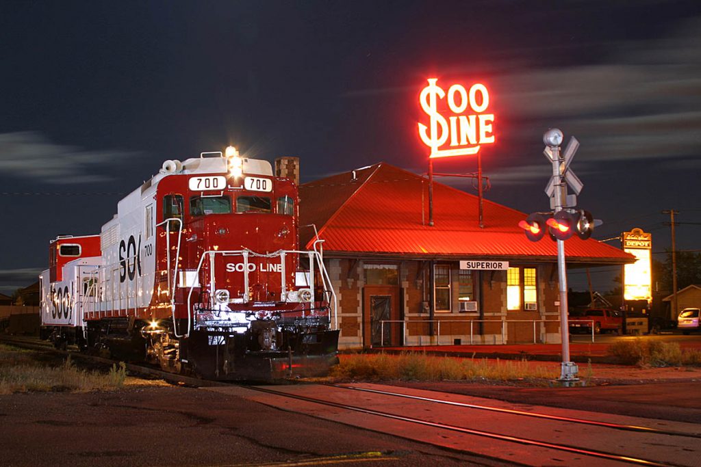 A Soo Line train rides by the Soo Line Station at night.