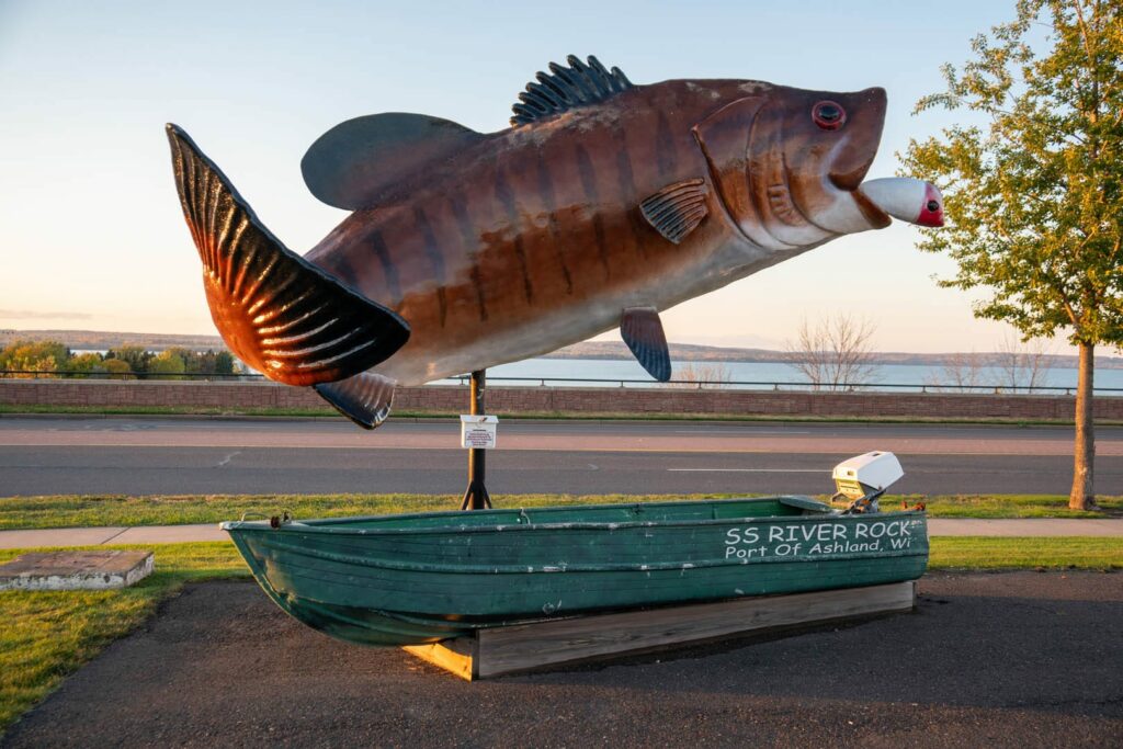 A large sculpture of a fish with a little green boat underneath that says SS River Rock, Port of Ashland, Wisconsin.