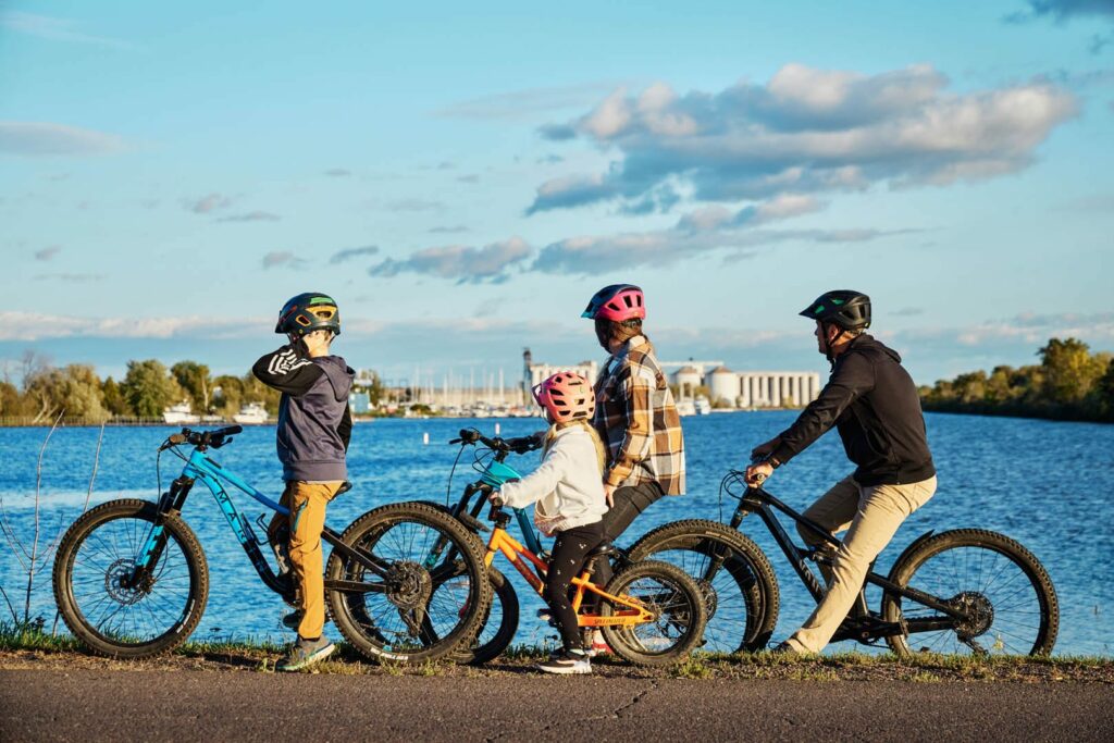A family biking along the very blue Lake Superior.