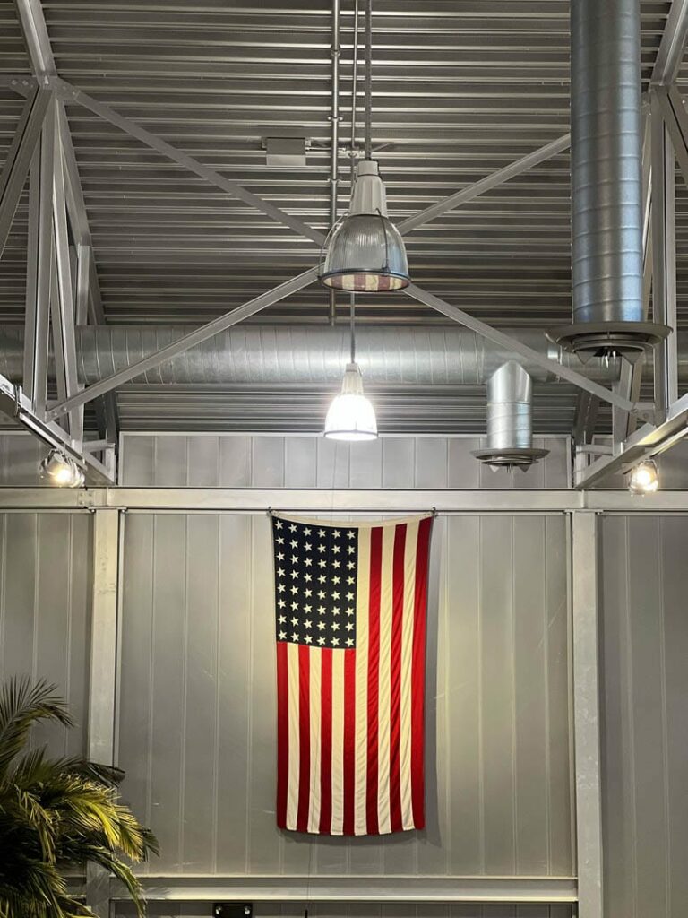 A bright light shines on the American Flag. It is hanging on the walls of the Richard I Bong Museum.