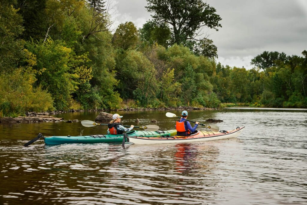 Two women kayaking along an inlet on the St. Louis River.