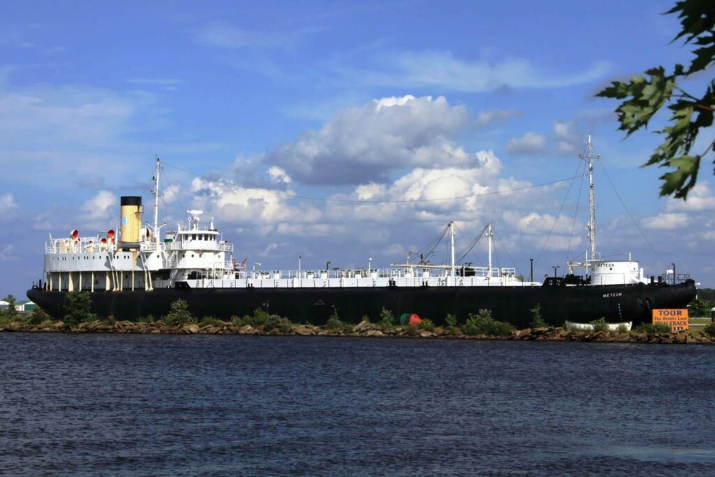 An outdoor shot of the entire length of the SS Meteor ship taken from the harbor.