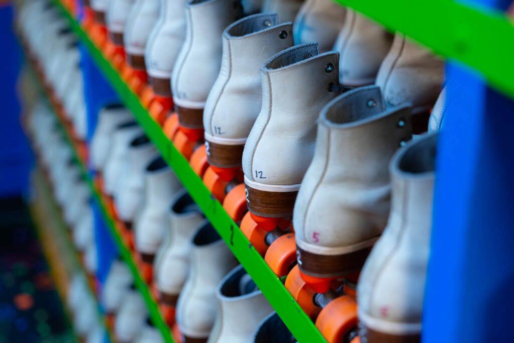 A whole bunch of roller skates in order of size for rent.