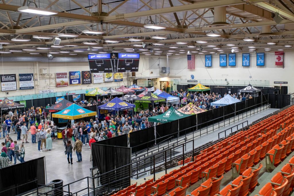 A large arena with at least two hundred people enjoying local beer offerings at an been event.