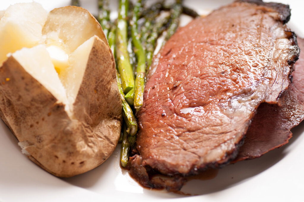 Prime rib dinner with baked potato and asparagus
