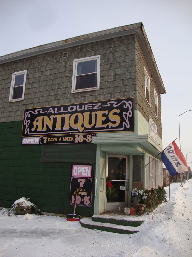 The outside of Allouez Antiques' storefront on a snowy day.