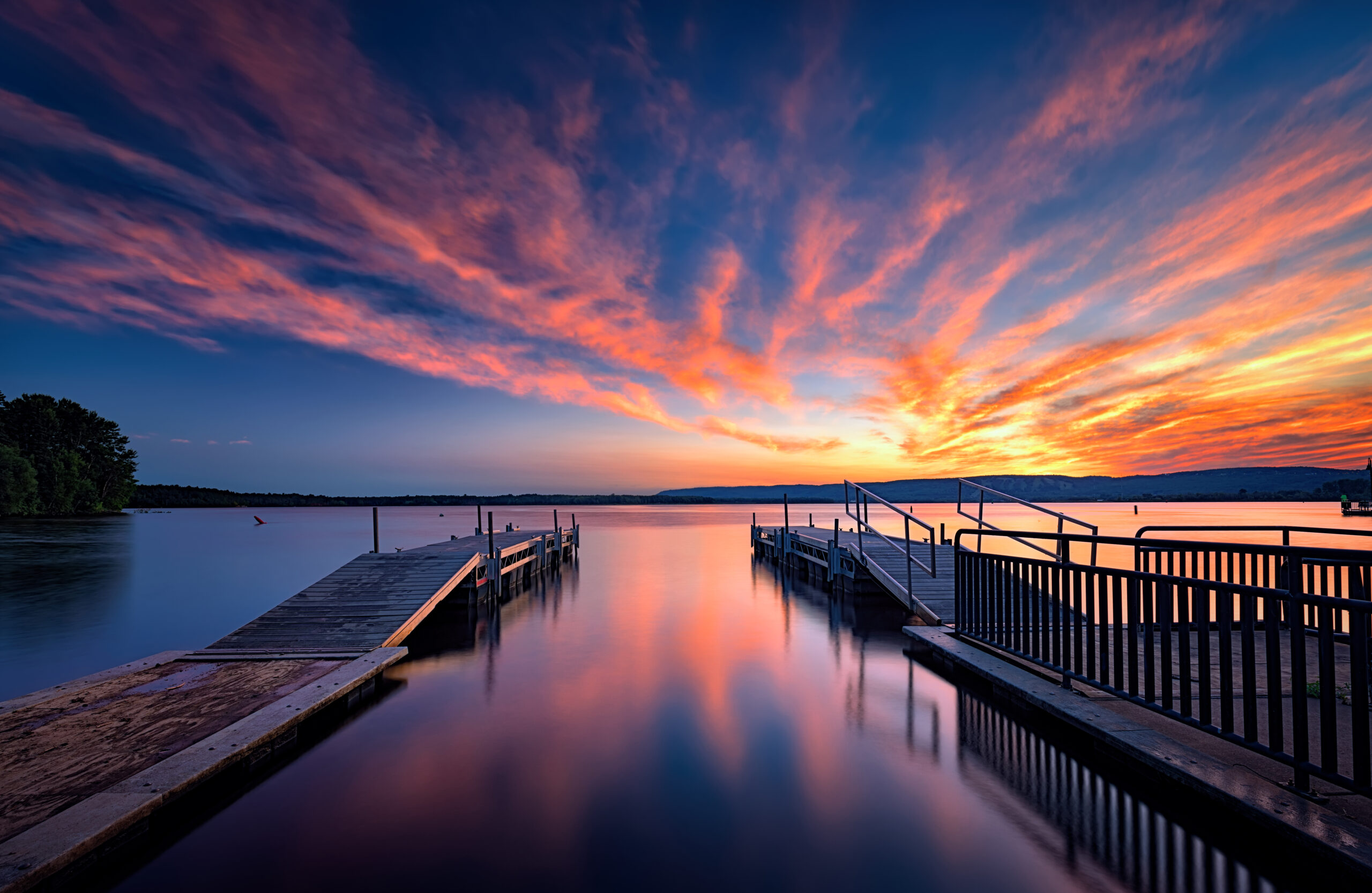 two docs side by side with a beaufiful sunset on the St. Louis River shoreline