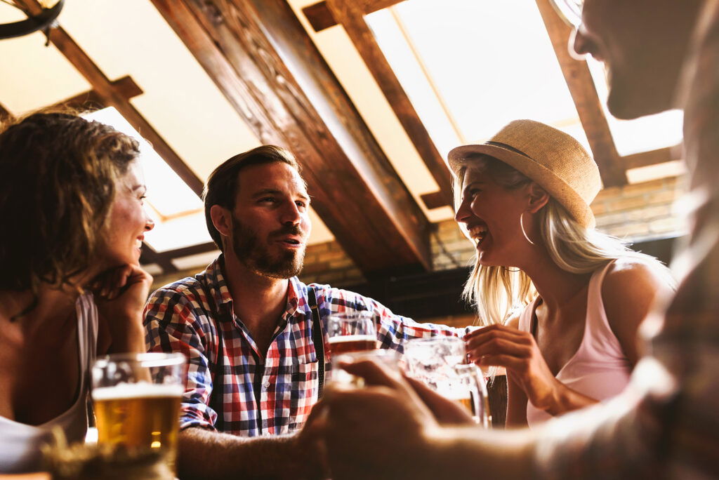 A group of people sitting at a table with glasses of beer, enjoying one of the best summer activities in Superior, Wisconsin.