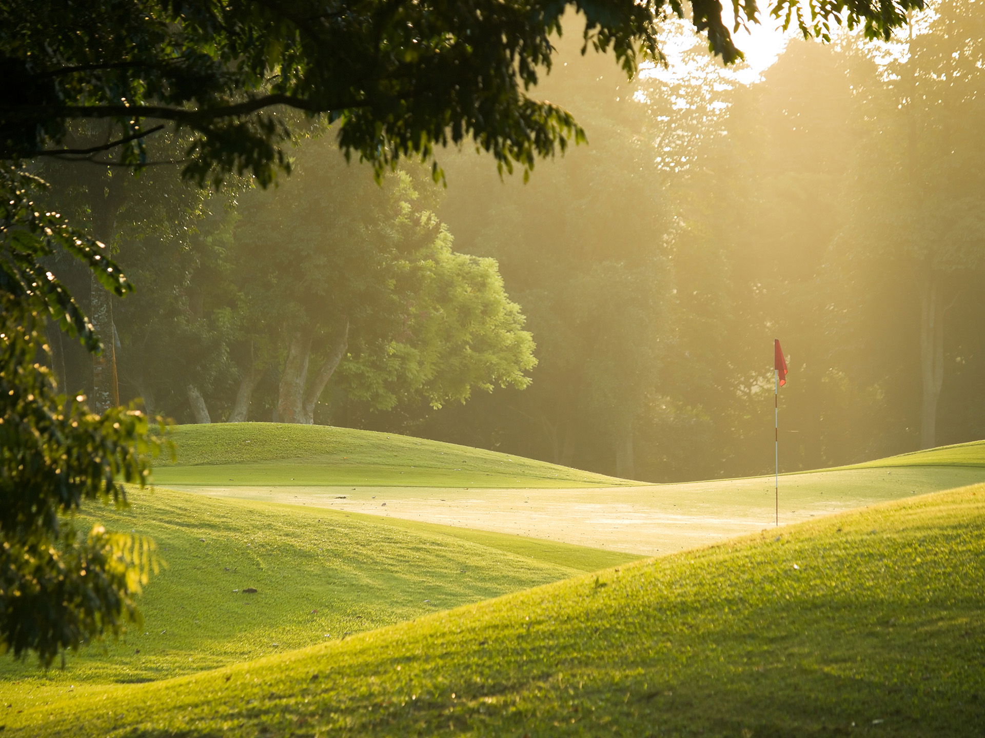 A golf course with a flag on the ground, perfect for enjoying summer activities in Superior Wisconsin.