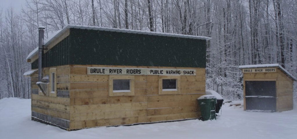 A small wooden building in the snow.