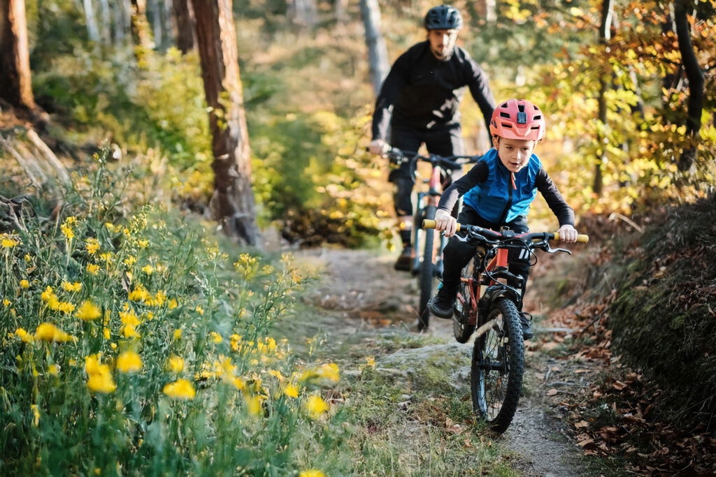 Father and son riding mountain bikes down a trail