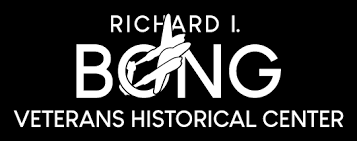 Logo for the Richard I. Bong Veterans Historical Center, featuring stylized text and an image of an aircraft overlaid on the letter "O" in "BONG.