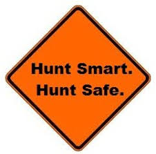 An orange diamond-shaped sign with black border displaying the text "Hunt Smart. Hunt Safe." in bold black letters.