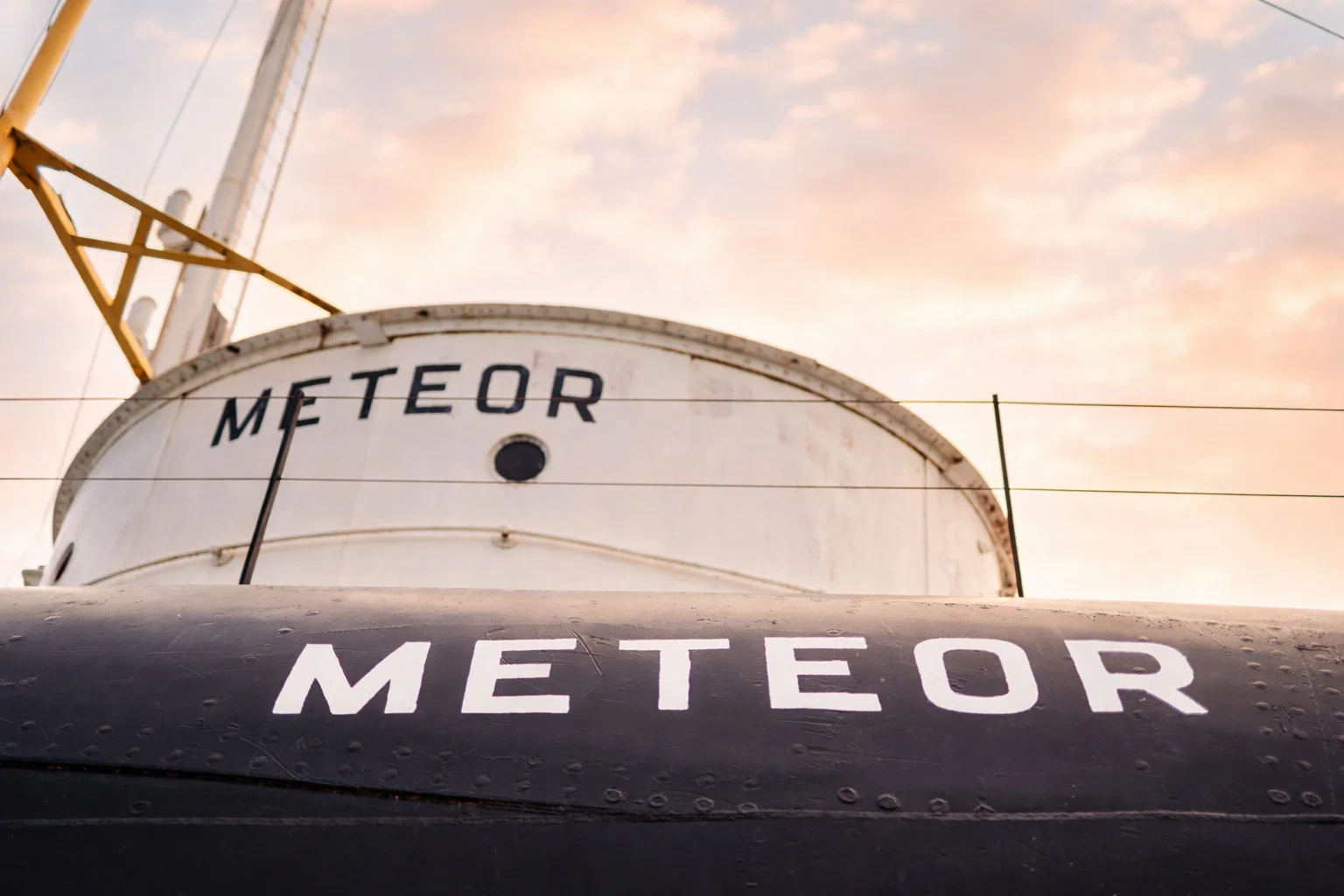 15% bottom Close-up view of a ship named "METEOR" in bold white letters on its black hull and white upper structure, set against a pastel sky—one of the unique Wisconsin places to visit in summer.
